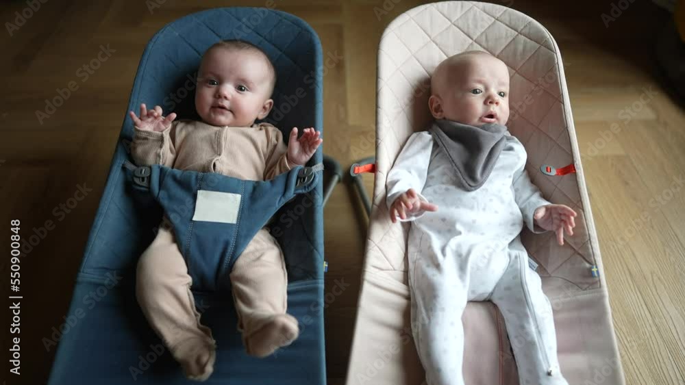 newborn baby twins in a rocking chair. happy family kid dream concept