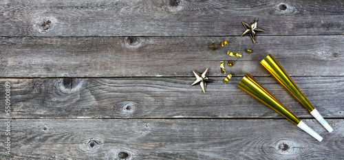 New Year celebration background with gold noisemakers, stars and confetti. Perfect for other events like Christmas, birthday or anniversary photo