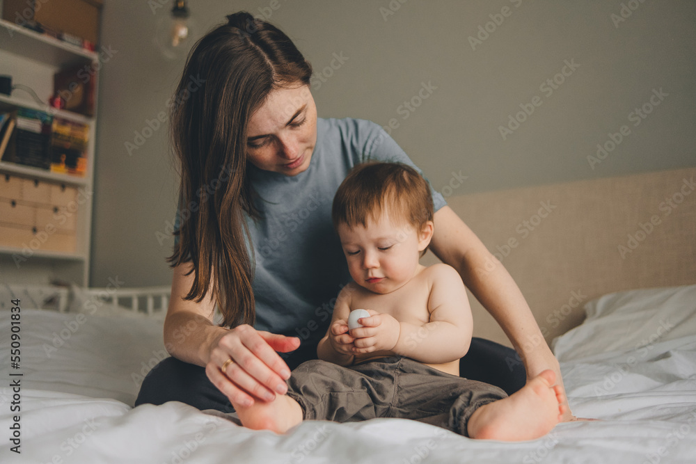 portrait of mother and child on the bed in the bedroom with a white bedspread portrait of mother and child on the bed in the bedroom with a white bedspread