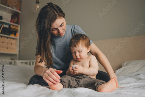 portrait of mother and child on the bed in the bedroom with a white bedspread