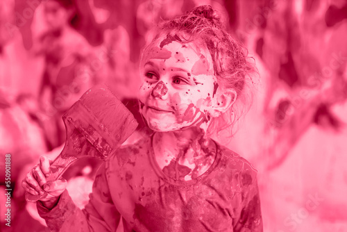 Fototapeta Naklejka Na Ścianę i Meble -  Pantone color 2023 viva magenta. Happy child girl hold paintbrush durty in the paint and all face stained with paint
