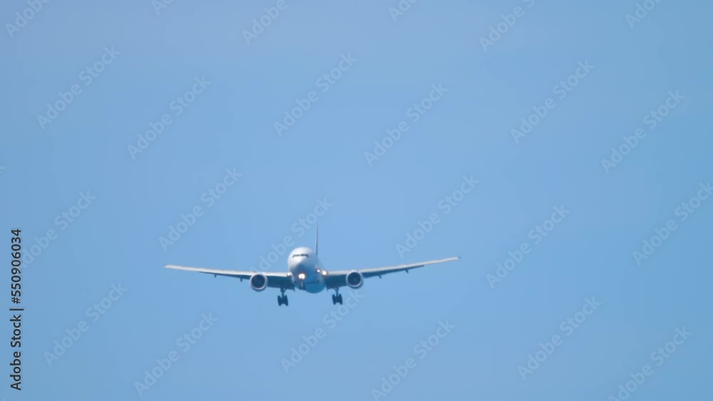 Jet passenger plane in the blue sky. Airliner descending for landing. Unrecognizable plane flies, arriving. Tourism and travel concept Jet passenger plane in the blue sky. Airliner descending for landing. Unrecognizable plane flies, arriving. Tourism and travel concept