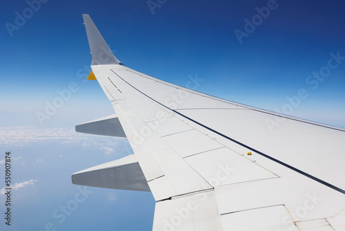 View from Inside an Aircraft: Window of the Cabin, White Airplane Wing and Clouds