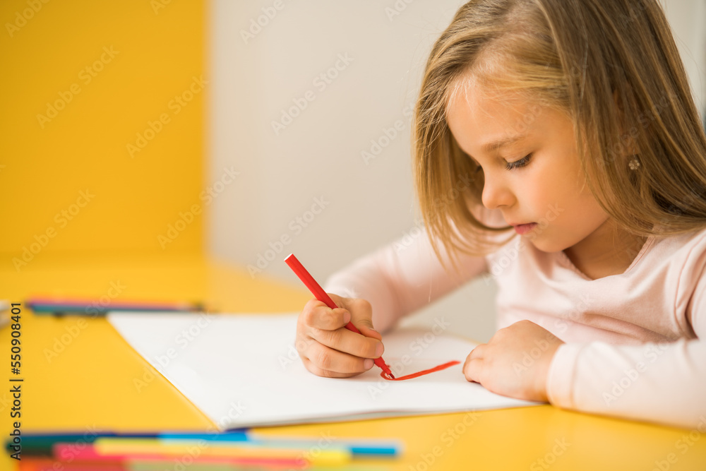 Beautiful little girl enjoys drawing at her home. Beautiful little girl enjoys drawing at her home.