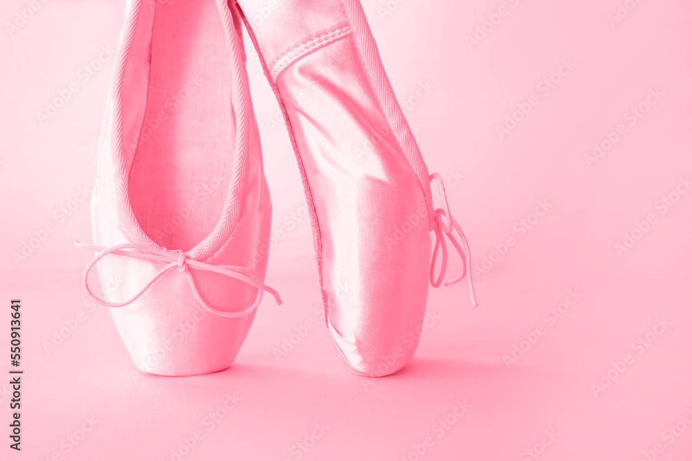 Pink pointe shoes for ballet close-up on a pink background. New 2023 trending PANTONE 18-1750 Viva Magenta color.