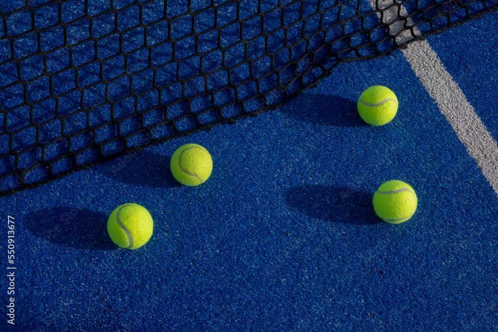 selective focus, four balls at the net on a paddle tennis court