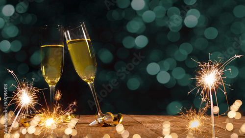 New Year Sylvester festive fireworks celebration holiday New Year's Eve greeting card banner - Toasting Champagne or sparkling wine glasses and sparklers on wooden table