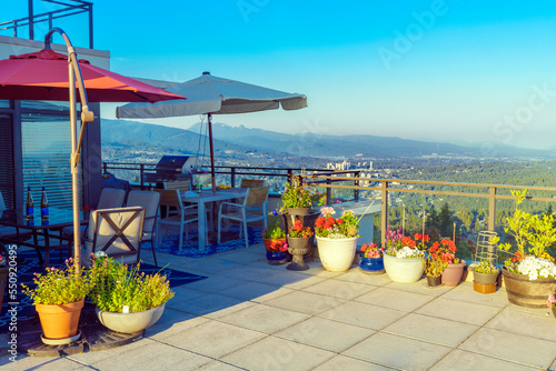 Flowers and shrubs on BC rooftop patio with extensive views across valley at the height of s
ummer. photo