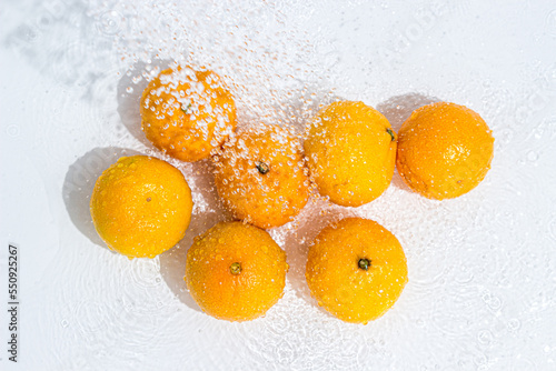 Tangerines in water on a white background. fruit washing