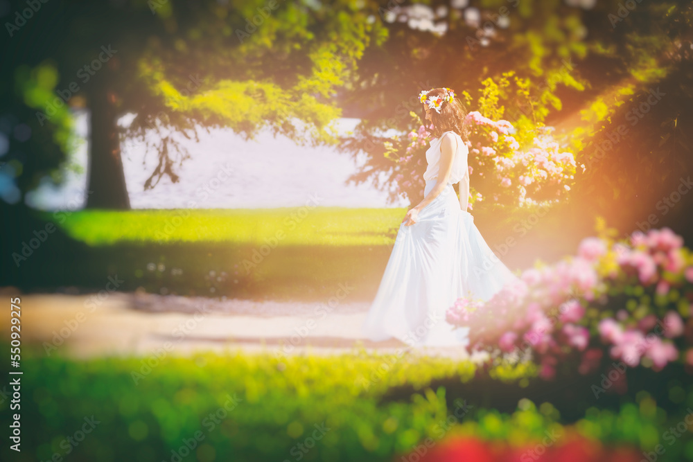 Outdoor portrait of young happy smiling fantasy woman walking among flowers. Young beautiful goddess enjoys spring nature in bright sunlight. Fairy tale image art photo with pink roses frame Outdoor portrait of young happy smiling fantasy woman walking among flowers. Young beautiful goddess enjoys spring nature in bright sunlight. Fairy tale image art photo with pink roses frame