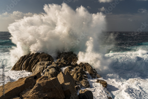 The waves of the ocean thunder against the rocky shore