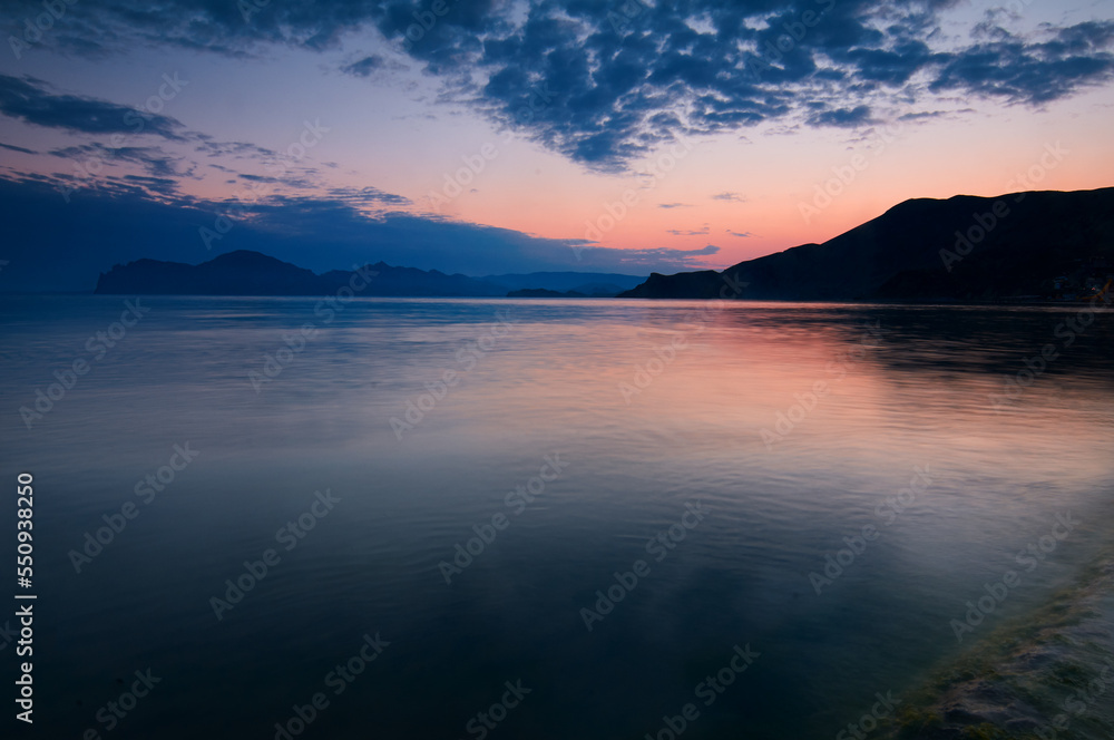 Dusk and dawn landscape. Beautiful Crimean sea bay at evening time.