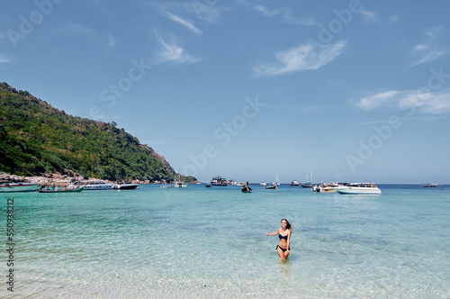 Vacation on the seashore. Young woman bathing on the beautiful tropical beach.