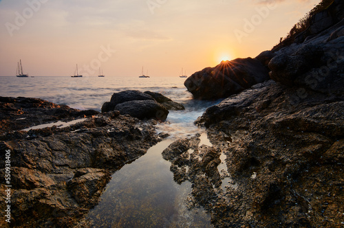 Sea landscape with sunset sky and boats on the horizon