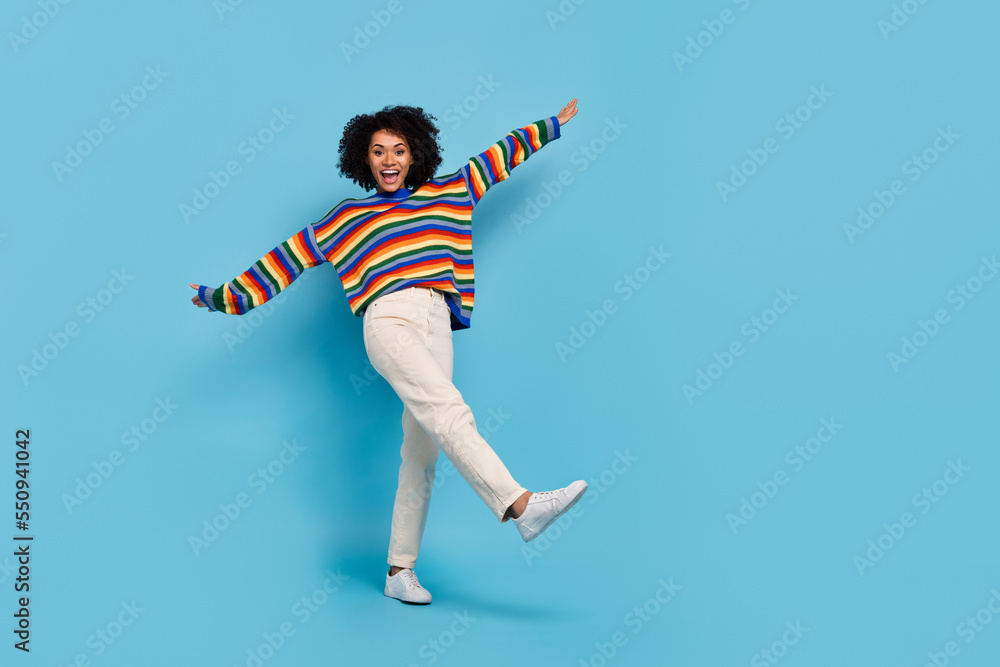 Full body photo of millennial wavy hairdo lady dance wear shirt jeans sneakers isolated on blue background Full body photo of millennial wavy hairdo lady dance wear shirt jeans sneakers isolated on blue background