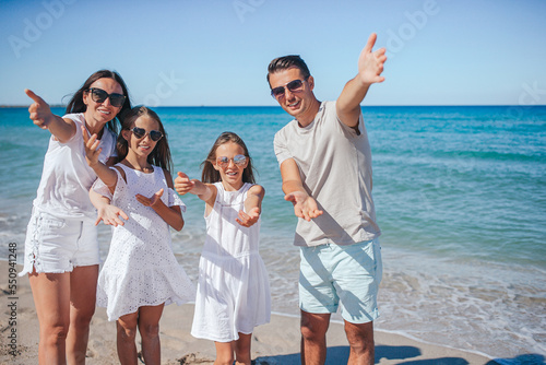 Portrait of young parent and two adorable daughters on the beach