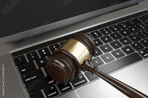 Judge gavel on a laptop. Illustration of the concept of new cybersecurity laws and regulations and its enforcement photo