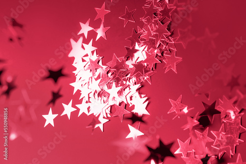 Shiny viva magenta stars glitter or confetti. Festive holiday backdrop and pattern. Via magenta color trendy 2023 background.