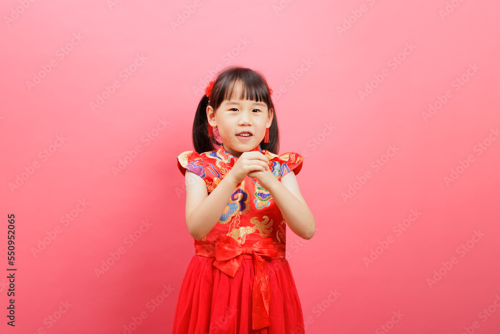 Chinese young girl with traditional dress with gesture of happy new year congratulation isolated on pink background. Chinese young girl with traditional dress with gesture of happy new year congratulation isolated on pink background.