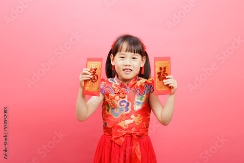 Chinese girl with traditional dressing up and holding a "FU" means "lucky" red envelope