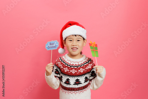 Merry Christmas! Young girl celebrating Christmas against pink background © M-image