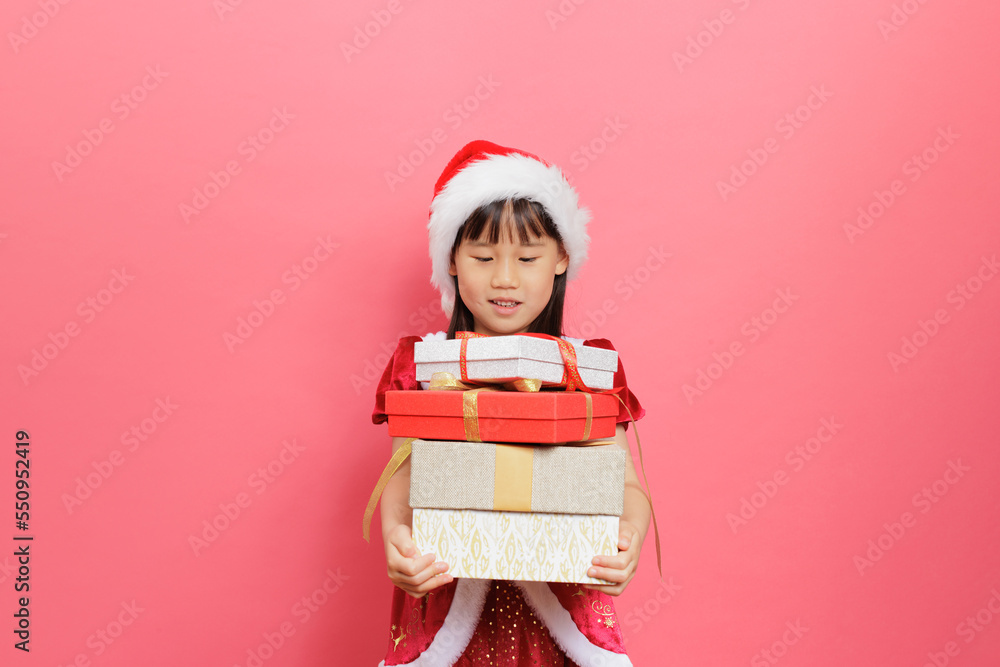 Merry Christmas! Young girl celebrating Christmas against pink background Merry Christmas! Young girl celebrating Christmas against pink background