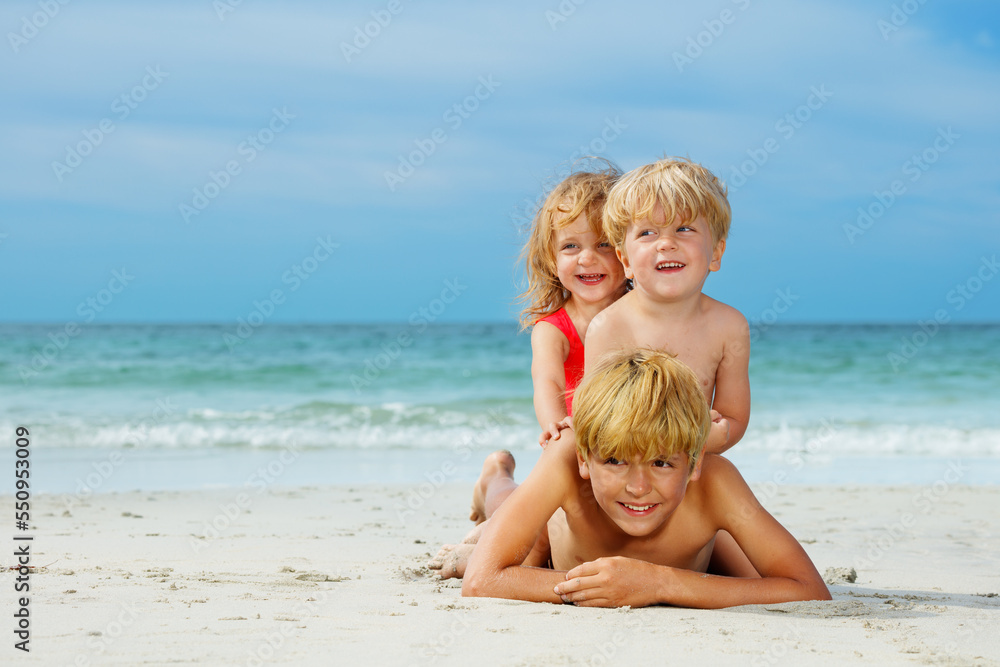 Three boys and a girl children lay on top of another