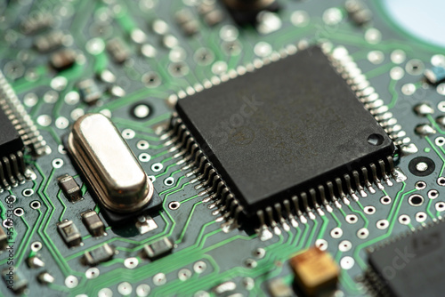 Small microprocessor, microcontroller chip on a generic modern desktop PC computer motherboard, object macro, extreme closeup, shallow dof, nobody Electrical components shortage concept, circuit board photo