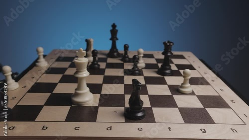 Chess in slowmo falls off the board. The camera is fixed on a chessboard.