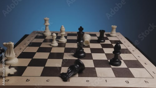 Chess in slowmo falls off the board. The camera is fixed on a chessboard.