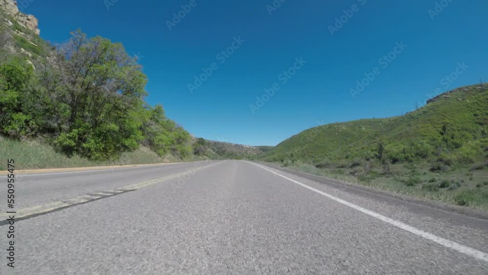 Low Angle of Road Through Bright Green Valley With Blue Sky Overhead in Mesa Verde Low Angle of Road Through Bright Green Valley With Blue Sky Overhead in Mesa Verde