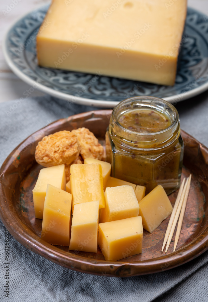 Cheese tasting, small pieces of old Dutch hard cheese and bowl with homemade dill-mustard sauce Cheese tasting, small pieces of old Dutch hard cheese and bowl with homemade dill-mustard sauce