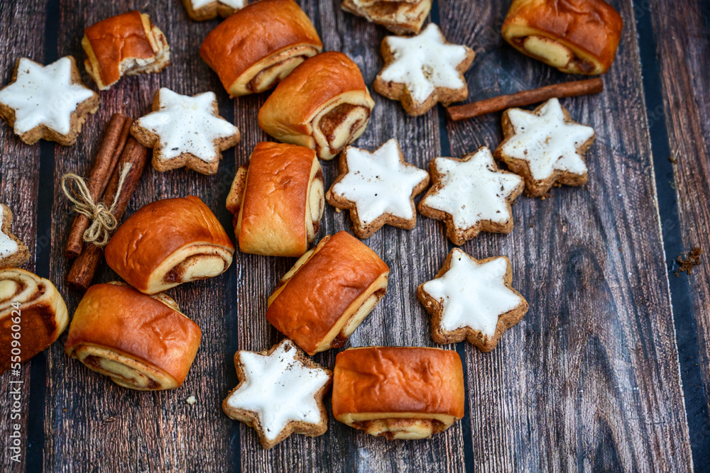 Freshly baked cinnamon buns with spices and cocoa filling on parchment paper. Top view. Sweet Homemade Pastry christmas baking. Close-up. Kanelbule - swedish dessert.and star shaped Christmas cookies Freshly baked cinnamon buns with spices and cocoa filling on parchment paper. Top view. Sweet Homemade Pastry christmas baking. Close-up. Kanelbule - swedish dessert.and star shaped Christmas cookies