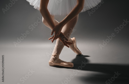 Close-up of ballet dancer's legs in pointe shoes and hands