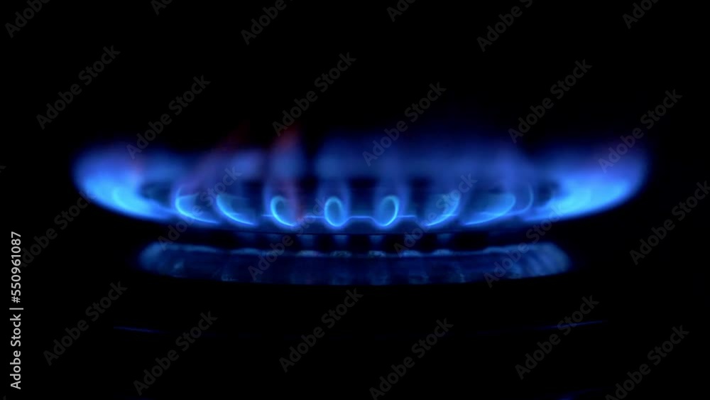 Gas stove ignites on a black background. Gas is switching on, apearing