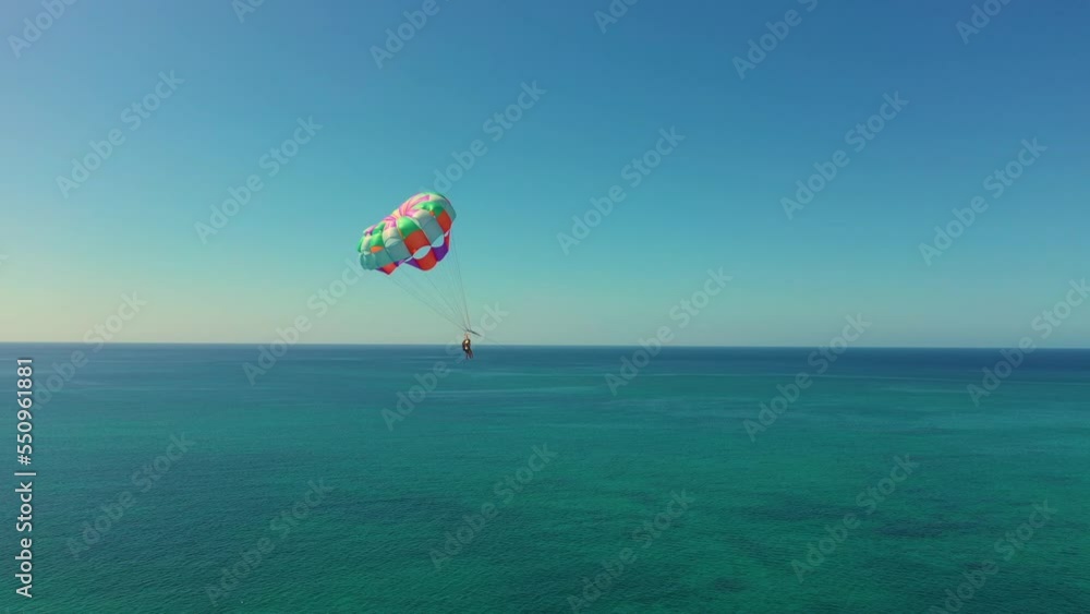 Aerial view of Parasailing, also known as parascending, paraskiing or parakiting. West Caribbean coast in Jamaica, Negril. Parachuting man in the air. parachute over the Seven Mile Beach. Aerial view of Parasailing, also known as parascending, paraskiing or parakiting. West Caribbean coast in Jamaica, Negril. Parachuting man in the air. parachute over the Seven Mile Beach.