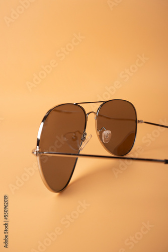 brown mirrored sunglasses with anti-reflective coating and UV protection on a orange background photo