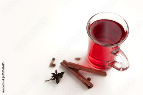 a glass cup of a red warming drink (tea, mulled wine, punch). ingredients for winter hot drinks.