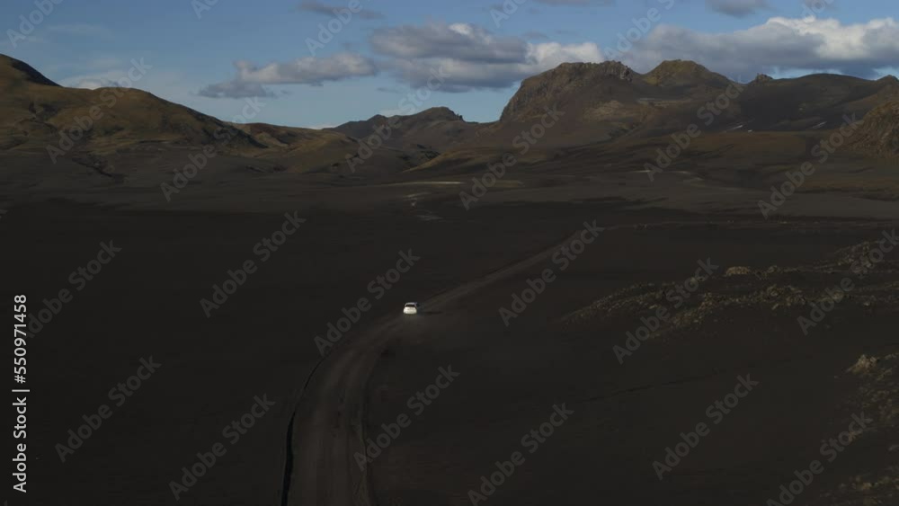 Aerial view of car driving in remote landscape / Highlands, Iceland Aerial view of car driving in remote landscape / Highlands, Iceland
