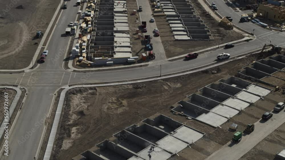 Aerial flyover view of foundations of housing development under construction / Riverton, Utah, United States Aerial flyover view of foundations of housing development under construction / Riverton, Utah, United States