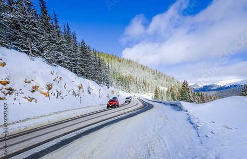 View of mountain highway in Colorado, USA, in winter  with driving cars in foreground and sky in background