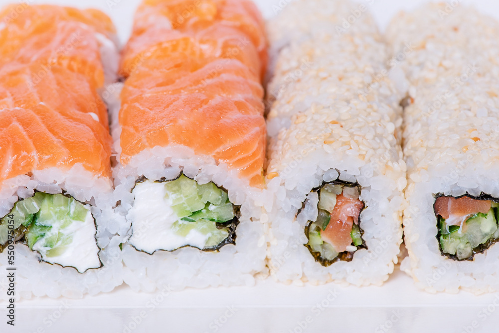 Japanese food rolls in sesame with salmon, cucumber, Philadelphia cheese. Food delivery. Japanese food rolls in sesame with salmon, cucumber, Philadelphia cheese. Food delivery.