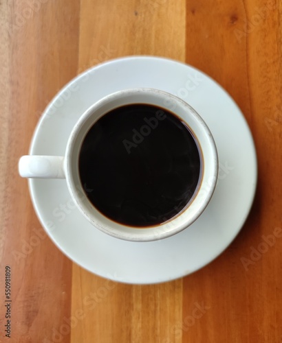 A cup of black coffee on wooden table