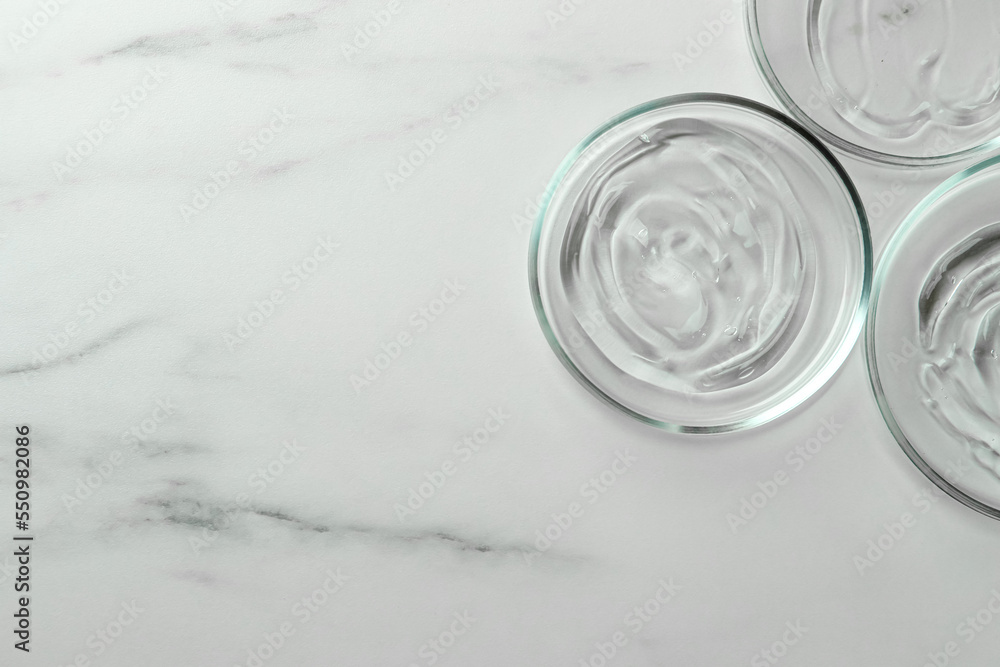 Petri dishes with liquids on white marble table, flat lay. Space for text Petri dishes with liquids on white marble table, flat lay. Space for text