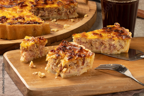 Slices of cheese and bacon quiche with black coffee.