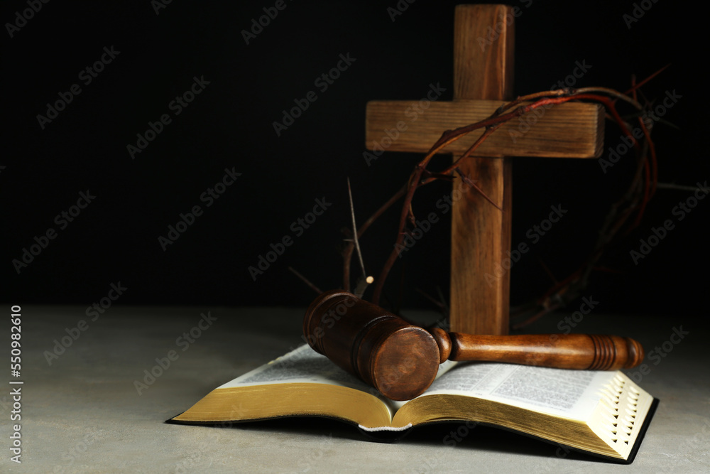 Judge gavel, bible, wooden cross and crown of thorns on grey table