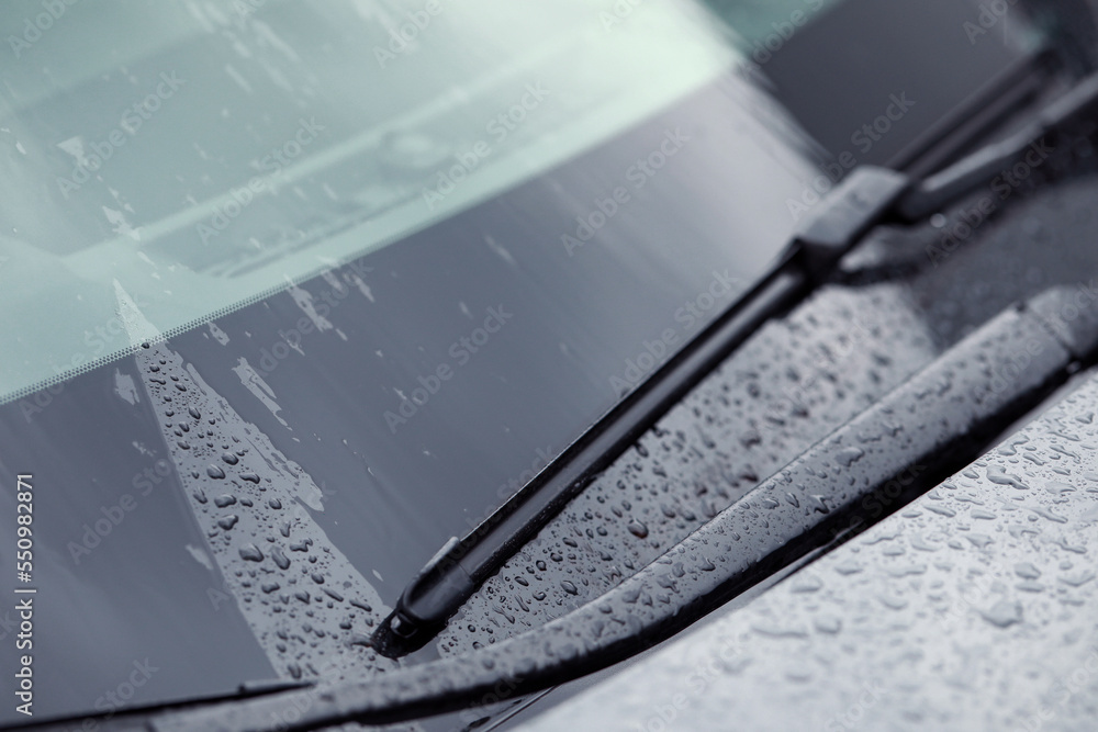 Car wiper cleaning water drops from windshield glass, closeup - obrazy, fototapety, plakaty 