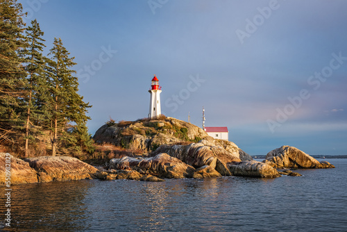 View of a Lighthouse on a rocky coast during a cloudy day, historic landmark Point Atkinson Lighthouse in West Vancouver photo