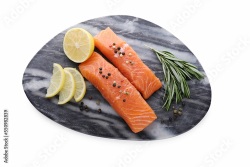Pieces of fresh raw salmon, spices and lemon slices isolated on white, top view
