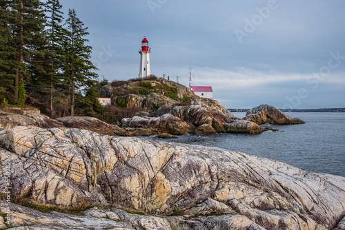 View of a Lighthouse on a rocky coast during a cloudy day, historic landmark Point Atkinson Lighthouse in West Vancouver photo